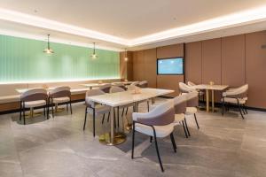 a conference room with tables and chairs and a screen at Atour X Hotel Zhuhai Gongbei Port High Speed Railway Station in Zhuhai