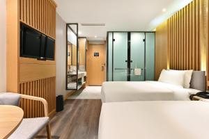 a hotel room with two beds and a flat screen tv at Atour X Hotel Beijing Sanlitun Agricultural Exhibition Hall in Beijing