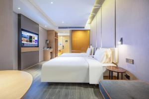 a hotel room with two beds and a flat screen tv at Atour Hotel Hefei North Square South Station in Hefei