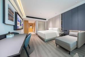 a hotel room with a bed and a desk and chairs at Atour X Hotel Guangzhou Baiyun International Airport Renhe Station in Guangzhou