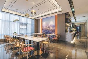 um restaurante com mesas e cadeiras e uma grande janela em Atour S Hotel Chongqing Crown International em Chongqing