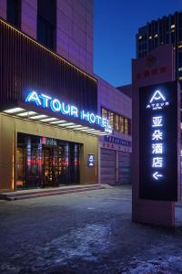 un magasin avec un panneau devant un bâtiment dans l'établissement Atour Hotel Harbin Haxi High Speed Railway Station, à Harbin