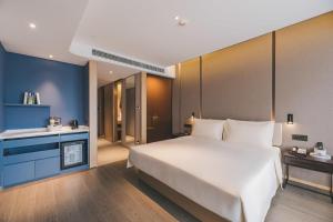 Atour S Hotel Shanghai Xujiahui Tianyaoqiao tesisinde bir odada yatak veya yataklar