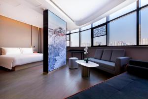 a hotel room with a bed and a couch at Atour Hotel Taian Taishan Internation Convention and Exhibition Center in Tai'an
