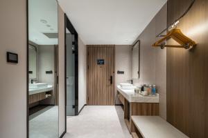 a bathroom with two sinks and a mirror at Atour Hotel Anji Longshan in Anji