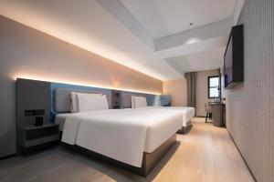 Atour Light Hotel Wuhan Jiangtan Jianghan Road Pedestrian Street tesisinde bir odada yatak veya yataklar