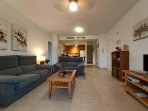 a living room with two blue couches and a coffee table at Spacious and luxurious apartment in Mojácar