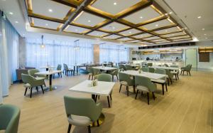 une salle à manger avec des tables et des chaises dans un restaurant dans l'établissement Atour Hotel Shenzhen Nanshan Shekou, à Shenzhen