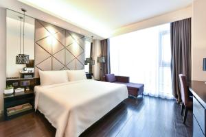 ein Hotelzimmer mit einem großen weißen Bett und einem Stuhl in der Unterkunft Atour Hotel Beijing Yizhuang West Rongjing Street in Daxing