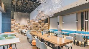 a restaurant with tables and chairs and chandeliers at Atour Hotel Ningbo Sanjiangkou Bund Book City in Ningbo