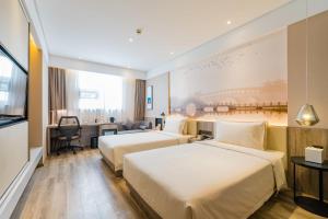 a hotel room with two beds and a desk at Atour Hotel Xuzhou East Jianguo Road Suning Plaza in Xuzhou