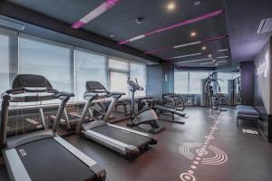 a gym with several treadmills and elliptical machines at Atour Hotel Jinan Grand View Garden in Jinan