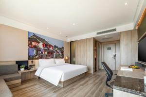 - une chambre avec un grand lit blanc et un bureau dans l'établissement Atour Hotel Shanghai Minhang Industrial Park, à Shanghai