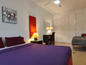 a bedroom with a large purple bed and a chair at Spacious and luxurious apartment in Mojácar +42 photos