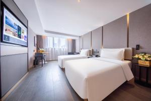 上海市にあるAtour Hotel Shanghai Xinzhuang CBDのベッド2台、薄型テレビが備わるホテルルームです。