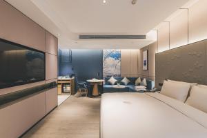 um quarto de hotel com uma cama e uma sala de estar em Atour S Hotel Chongqing Crown International em Chongqing