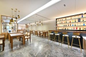 un restaurante con un bar con mesas y sillas de madera en Atour X Hotel Beijing Sanlitun Agricultural Exhibition Hall, en Beijing