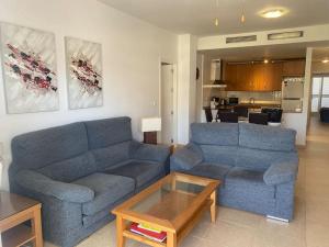 a living room with a blue couch and a coffee table at Spacious and luxurious apartment in Mojácar
