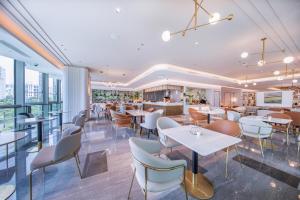 ein Restaurant mit Tischen und Stühlen und eine Bar in der Unterkunft Atour Hotel Shenzhen Futian Xiangmi Lake in Shenzhen