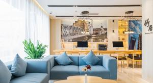 a living room with a blue couch and a table at Atour Hotel Shanghai Hongqiao National Exhibition Center Wuzhong Road in Shanghai
