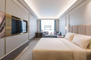 成都市にあるAtour Hotel Chengdu Kuanzhai Alleyのベッド1台、薄型テレビが備わるホテルルームです。