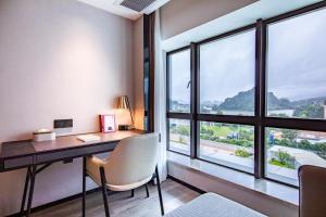 a desk in a room with a large window at Atour Hotel Zhaoqing Qixingyan in Zhaoqing