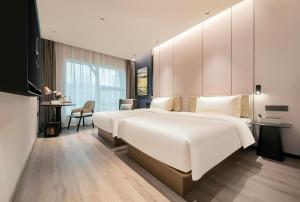 a bedroom with a large white bed and a desk at Atour Hotel Shanghai Lujiazui Pudong Avenue in Shanghai