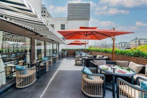a restaurant with tables and umbrellas on a patio at Atour X Hotel Shanghai Pudong Zhangjiang Park in Shanghai