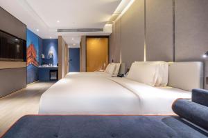 un grande letto bianco in una camera con divano di Atour Hotel Yichun Administrative Center a Yichun