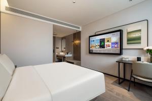 a hotel room with a bed and a flat screen tv at Atour Hotel Anji Longshan in Anji +19 photos