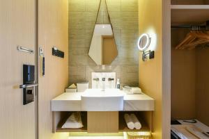 y baño con lavabo blanco y espejo. en Atour Hotel Beijing Wangjing 798 Art District en Beijing