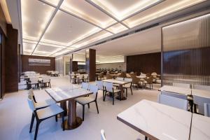 une salle à manger avec des tables et des chaises ainsi qu'une salle de classe dans l'établissement Atour X Hotel Guangzhou Baiyun International Airport Renhe Station, à Canton