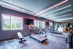 um ginásio com vários equipamentos de exercício numa sala com janelas em Atour Hotel Qingdao Laoshan Shilaoren Beach em Qingdao