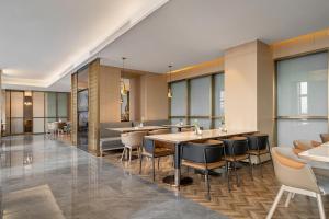 ein Restaurant mit Tischen, Stühlen und Fenstern in der Unterkunft Atour S Hotel Xining Haihu New District SDIC Plaza in Xining