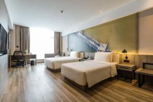 una habitación de hotel con 2 camas y una gran pintura en Atour Hotel Ningbo Laowaitan, en Ningbo