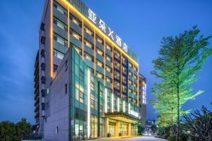 un edificio de oficinas con una fachada iluminada en Atour X Hotel Shenzhen Guanlan Shanshui Pastoral, en Lung Wa