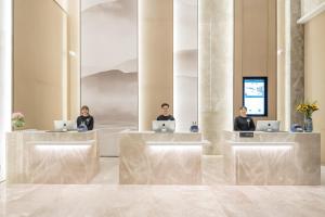 three people sitting in a lobby with their laptops at Atour Hotel Changzhou Wujin Science and Education City in Changzhou