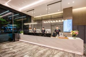 a lobby with four people working at computers at Atour X Hotel Chaozhou Xiangqiao International Financial Business Center in Chaozhou