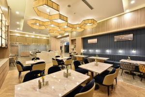 un ristorante con tavoli, sedie e un lampadario di Atour Hotel Beijing Yizhuang Mobile Silicon Valley a Daxing