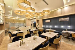 un restaurant avec des tables et des chaises et un lustre dans l'établissement Atour Hotel Beijing Yizhuang Mobile Silicon Valley, à Daxing