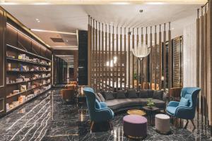a lobby with a couch and chairs and books at Atour Hotel Shanghai Hongqiao International Exhibition Linkong Park in Shanghai