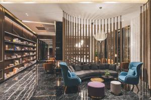 una hall con divano, sedie e libri di Atour Hotel Shanghai Hongqiao International Exhibition Linkong Park a Shanghai
