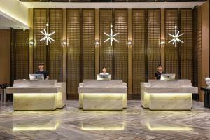 drie mensen aan tafel in een lobby met hun laptops bij Atour Hotel Dongguan Nancheng International Trade Center in Dongguan