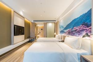a hotel room with two beds and a tv at Atour Hotel Ningbo International Convention and Exhibition Center in Ningbo