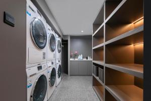 a laundry room with three washer and dryers at Atour Light Hotel Wuhan Jiangtan Jianghan Road Pedestrian Street in Wuhan +8 photos
