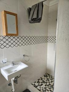 une salle de bain blanche avec un lavabo et un miroir dans l'établissement Vintage@1420, à Ngodini 37 autres photos
