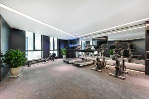 une salle de sport avec des tapis roulants et des appareils d'exercice dans un bâtiment dans l'établissement Atour Hotel Tianjin Eye, à Tianjin