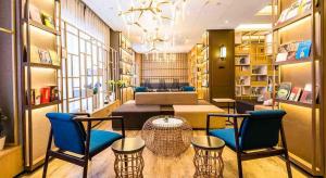 a room with chairs and a table in a library at Atour Hotel Zhongshan Er Road Lihe Plaza in Zhongshan