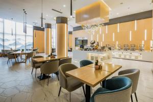 un restaurante con mesas y sillas y una cocina en Atour Hotel Yantai Golden Beach, en Yantai