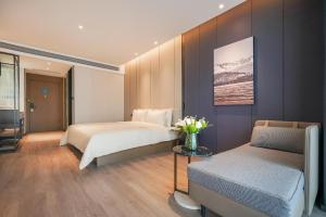 a bedroom with two beds and a vase of flowers at Atour Hotel Chengdu East Station Greenland 468 Center in Chengdu